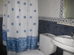 a bathroom with a white toilet and a sink at El Duje in Tielve