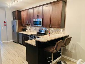 a kitchen with wooden cabinets and a stove top oven at Upscale 2BD/1.5BA townhome mins to JHH & downtown in Baltimore