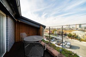 a balcony with a table and chairs and a view of a city at Suwon Dono1796 Hotel in Suwon