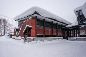 a building covered in snow with snow around it at Gondola Chalet by H2 Life in Kutchan