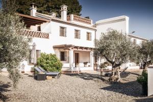 una gran casa blanca con árboles delante de ella en Casa Grande / Rosas Cantares en Pizarra