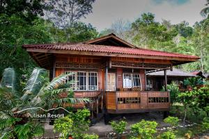una casa in legno in mezzo a una foresta di Pulisan Resort a Rinondoran