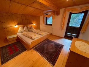 ein Schlafzimmer mit einem Bett in einem Zimmer mit Holzböden in der Unterkunft Alpengasthof Wegscheid in Kelchsau
