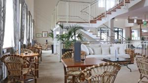 sala de estar con mesas, sillas y sofá en Precise Resort Rügen & SPLASH Erlebniswelt en Sagard