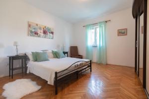 1 dormitorio con 1 cama y suelo de madera en Country Home Matkovic - Duba, en Čilipi