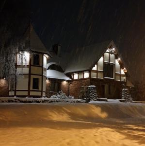 馬爾堡的住宿－Apartamenty Milenijna 2 MALBORK Nowa Wieś，夜晚有雪覆盖的房子