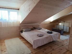 um quarto com uma cama grande num quarto de madeira em Бо&Не em Yablunytsya