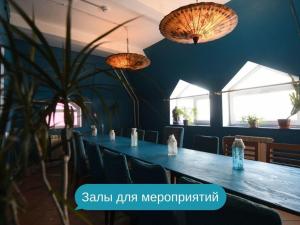 モスクワにあるSkazka Asia Design Hotel in Izmailovo Kremlinのダイニングルーム(長いテーブル、椅子、2つの照明付)
