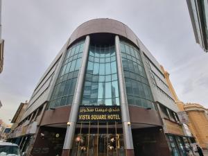 ein großes Glasgebäude mit einem begehbaren Quadratmeterhotel in der Unterkunft Vista Square Hotel in Dubai