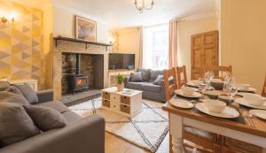 a living room with a table and a fireplace at Potters Retreat in Alnwick