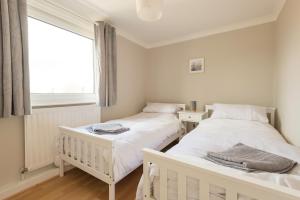 two twin beds in a room with a window at Potters Retreat in Alnwick