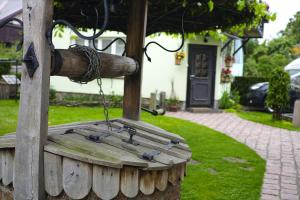 un banco de madera con una cadena en un patio en Adomo Rojus, en Palanga