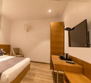 een hotelkamer met een bed en een flatscreen-tv bij TRIBHAV Corbett Bliss-Jim Corbett in Rāmnagar