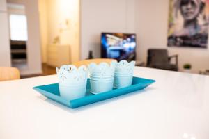 a tray with four cups on a table at Moderne 2-Zimmer Wohnung! WLAN und Netflix inklusive! Zentral gelegen in der historischen Altstadt! in Stade