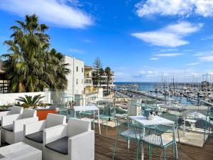 a balcony with tables and chairs and a marina at Regina Margherita - Bed and Breakfast & Rooftop Lounge Bar in Siracusa