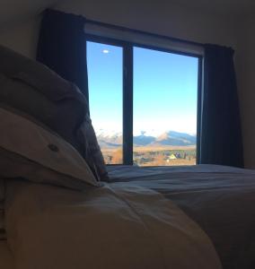 a bedroom with a bed and a window with a view at Alpine Loft in Lake Tekapo