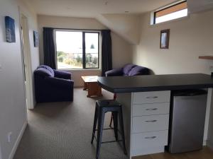 a room with a counter and two chairs and a desk at Alpine Loft in Lake Tekapo