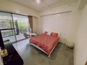 sypialnia z łóżkiem, stołem i oknem w obiekcie 遊虎尾 w mieście Huwei