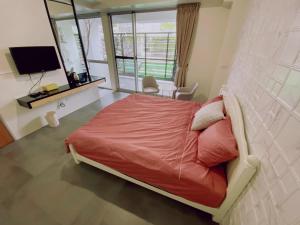 Schlafzimmer mit einem Bett mit einer roten Bettdecke in der Unterkunft 遊虎尾 in Huwei