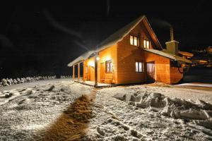 a house is covered in snow at night at Ostoja Bieszczady in Lutowiska