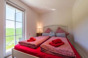 a bedroom with two red pillows on a bed with a window at Luxus Chalet Salzenweiler in Loßburg