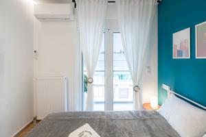 sypialnia z łóżkiem i dużymi szklanymi drzwiami w obiekcie Aphrodite Apartment w Atenach