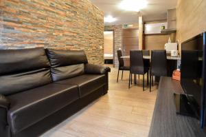 uma sala de estar com um sofá de couro e um bar em Apartamentos Turísticos Toledo em Toledo