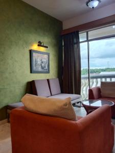 a living room with a couch and a balcony at Glory beach resort private apartment in Port Dickson