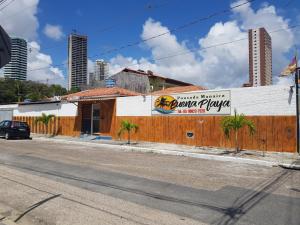 a building with a sign on the side of a street at Pousada Manaíra Buena Playa in João Pessoa