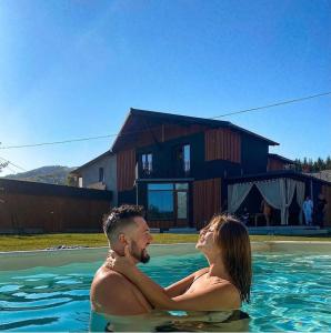 a man and woman swimming in a swimming pool at MiShelter in Migovo
