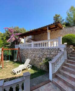 a villa with a stone wall and a stone staircase at Apartments Villa Jagoda in Rab