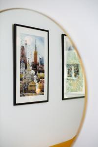 two framed photographs on a wall in a mirror at Sienna 65 Premium Apartment with Parking in Warsaw by Renters Prestige in Warsaw