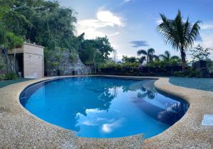 een zwembad met blauw water en bomen op de achtergrond bij Pier Uno Dive Resort powered by Cocotel in Mabini