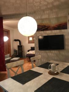 een woonkamer met een eettafel en een televisie bij Schöne Wohnung mit abgeschlossenem Grundstück zentral und ruhig in Greifswald