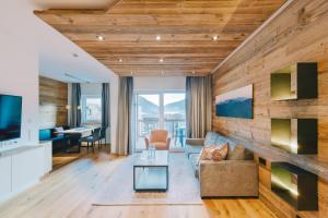 ein Wohnzimmer mit Holzwänden und einer Couch und einem Tisch in der Unterkunft Venediger Lodge in Neukirchen am Großvenediger