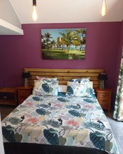 1 dormitorio con 1 cama con paredes moradas en Margayillat, en Manapany-les Bains
