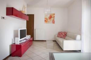 a living room with a couch and a television on a table at Casa Cariza-Appartamento con piscina in Colà di Lazise