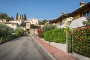 uma rua vazia numa aldeia com casas em Casa Cariza-Appartamento con piscina em Colà di Lazise