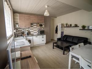 a living room with a black couch and a kitchen at Appartement Mont Dore face aux Thermes - Centre in Le Mont-Dore