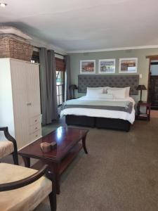 a bedroom with a large bed and a table at Bio-Pointment Guest Suites in Johannesburg