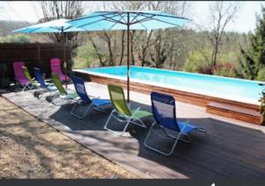 a group of chairs and umbrellas next to a swimming pool at L'Auberge du Périgord in Truffe