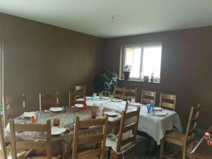 comedor con mesa, sillas y ventana en Les chambres d'hôtes de la Frissonnette en Auzelles
