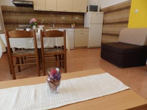 una mesa con un jarrón de fruta en una mesa en Apartments Villa Jagoda en Rab