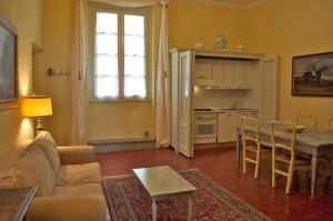 a living room with a couch and a table and a kitchen at Palazzo Tucci Apartments in Lucca
