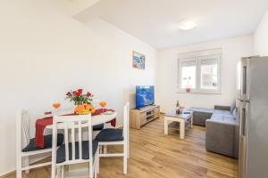 a kitchen and living room with a table and a couch at APARTMAN ANA, METKOVIĆ in Metković