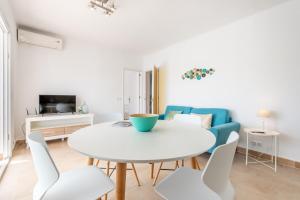un salon avec une table et des chaises blanches dans l'établissement Apartment Sa Caseta 2 by Mallorca House Rent, à Portopetro