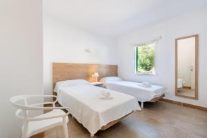 une chambre d'hôpital avec deux lits et un miroir dans l'établissement Apartment Sa Caseta 2 by Mallorca House Rent, à Portopetro
