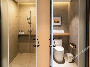 a bathroom with a toilet and a glass shower at Atour Light Hotel (Wuhan Wuchang Railway Station) in Wuhan