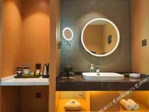 y baño con lavabo y espejo. en Atour Light Hotel (Wuhan Wuchang Railway Station) en Wuhan