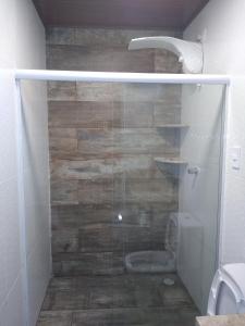 une douche avec une porte vitrée dans une salle de bain dans l'établissement Maravilhoso loft beira mar, à Japaratinga